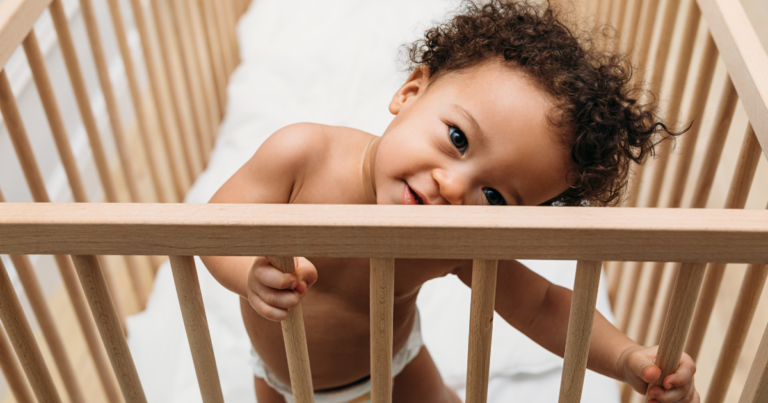 A toddler standing up in a crib