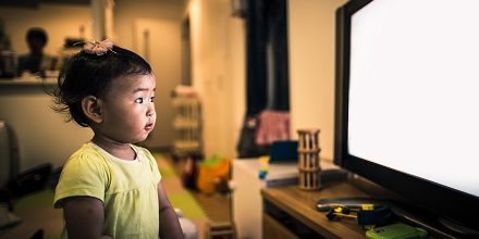 Kid watching TV that may contain toxic flame retardants.