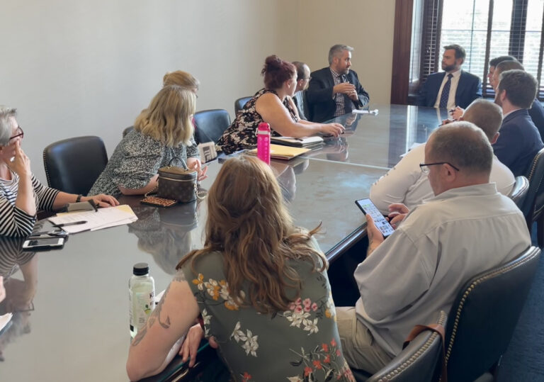 A group of people from the Unisty Council sitting around a conference table with Senator Vance